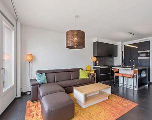 Moderne woonkamer van De Meeuwen vijfde vakantiehuis in Koksijde, West-Vlaanderen, met stijlvolle inrichting en open keuken.