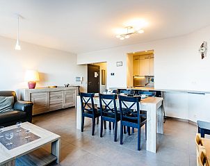 Gezellige woonkamer in Nepto gelijkvloers vakantiehuis, Koksijde, West-Vlaanderen. Comfortabele inrichting met eettafel en moderne keuken.