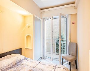 Slaapkamer in vakantiehuis Vitelli in Koksijde, West-Vlaanderen met balkon en natuurlijk licht.