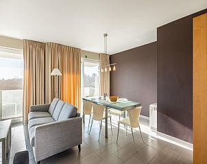 Lichte woonkamer van Vue Dunes vakantiehuis in Koksijde, West-Vlaanderen, met moderne inrichting en uitzicht op de natuur.