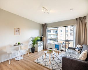 Stilvolles Wohnzimmer des Ferienhauses En Amoureux in Koksijde, Westflandern, mit moderner Einrichtung und Stadtblick.
