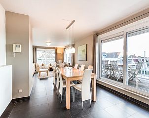 Ruime eetkamer van Le Penthouse in Koksijde, West-Vlaanderen met uitzicht op het terras en moderne inrichting.