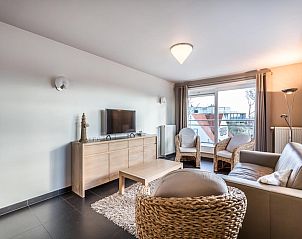 Stijlvolle woonkamer van Le Penthouse vakantiehuis in Koksijde, West-Vlaanderen, met comfortabele zithoek en uitzicht op de omgeving.