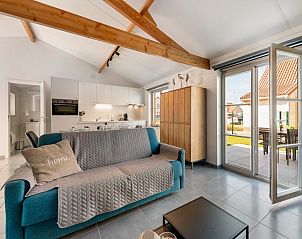 Gezellige woonkamer van vakantiehuis Westhinder I H92 in Koksijde, Belgi, met open keuken en toegang tot zonnig terras.