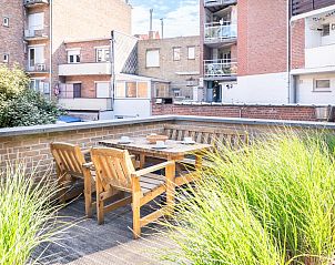 Gemtliche Terrasse im Ferienhaus Pablito Premier in Koksijde, Westflandern, umgeben von stdtischer Architektur und grnen Akzenten.