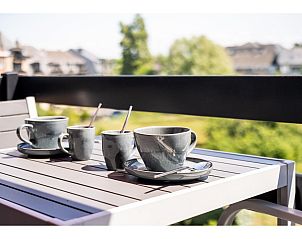 Genieen Sie eine Tasse Kaffee auf der Terrasse des Ferienhauses Ardoise des dunes in Koksijde, Westflandern, mit Blick auf die grne Umgebung.
