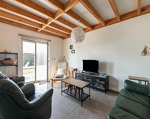 Gemtliches Wohnzimmer des Ferienhauses Westhinder I H4 in Koksijde, Westflandern, mit bequemer Sitzecke und Zugang zur Terrasse.