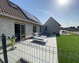 Genieen Sie die sonnige Terrasse des Ferienhauses Westhinder I H71 in Koksijde, Westflandern, mit moderner Sitzecke und grner Umgebung.