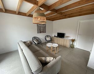 Gemtliches Wohnzimmer im Ferienhaus Westhinder I H71, Koksijde, mit modernem Mobiliar und Holzbalkendecke fr eine rustikale Atmosphre.