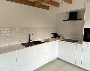 Moderne Kche im Ferienhaus Westhinder I H71, Koksijde, Westflandern, Belgien, mit schlichten weien Schrnken und stilvollen Oberflchen.
