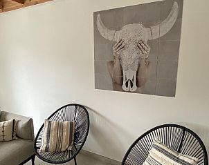 Stilvolles Wohnzimmer im Ferienhaus Westhinder I H71, Koksijde, Belgien mit moderner Kunst an der Wand und gemtlicher Sitzecke.