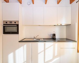 Moderne Kche im Ferienhaus Westhinder I H74, Koksijde, Westflandern, mit schlichten weien Schrnken und natrlichem Licht.