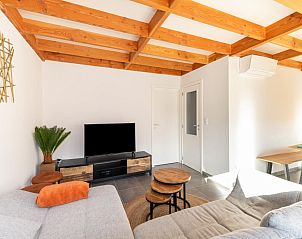Gemtliches Wohnzimmer im Ferienhaus Westhinder I H74 in Koksijde, Westflandern, mit Holzdecke und modernen Mbeln.