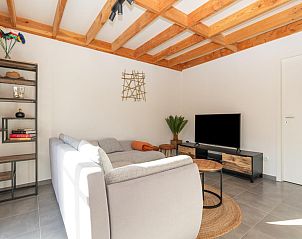 Gemtliches Wohnzimmer im Ferienhaus Westhinder I H74, Koksijde, Westflandern mit Holzbalkendecke und bequemer Sitzecke.