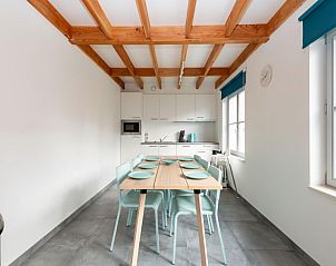 Modern dining room in vacation home Westhinder I H89, Koksijde, West Flanders, with wooden beams and lots of natural light.