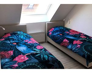 Schnes Schlafzimmer im Ferienhaus Westhinder I H36, Koksijde, mit bunten Steppdecken und viel Tageslicht.