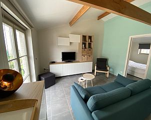 Gemtliches Wohnzimmer im Ferienhaus Westhinder I H93, Koksijde, mit bequemen Sitzgelegenheiten und moderner Einrichtung in Westflandern, Belgien.