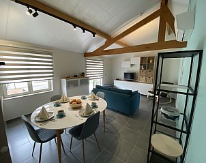 Gemtliches Wohnzimmer des Ferienhauses Westhinder I H93 in Koksijde, Westflandern, mit Essecke und modernen Mbeln.