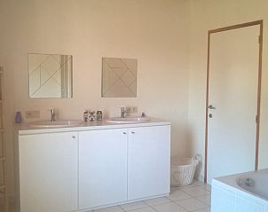 Ruime badkamer met dubbele wastafel in Villa Blanche, vakantiewoning in Lauwe, West-Vlaanderen.