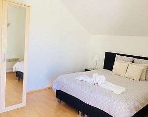 Lichte slaapkamer met spiegelkast in Villa Blanche, vakantieaccommodatie in Lauwe, West-Vlaanderen.
