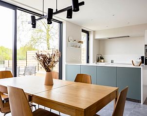 Stijlvolle eetkamer in Vakantiehuis in Lauwe, Belgi, met houten tafel en uitzicht op de tuin.