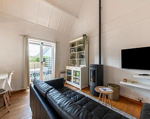 Gezellige woonkamer in vakantiehuis Nieuwendamme H114, Lombardsijde, met moderne inrichting en uitzicht op het terras in West-Vlaanderen.