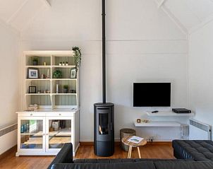 Gezellige woonkamer van vakantiehuis Nieuwendamme H114 in Lombardsijde, West-Vlaanderen met moderne inrichting en houtkachel.
