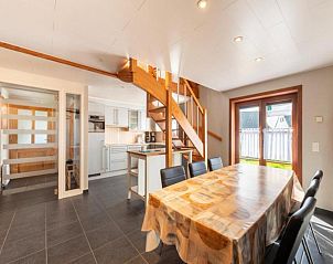 Gezellige eetkamer in vakantiehuis Nieuwendamme 108, Lombardsijde, West-Vlaanderen, met moderne keuken en houten trap.