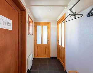 Inkomhal van vakantiehuis Nieuwendamme 108 in Lombardsijde, West-Vlaanderen, met houten deuren en tegelvloer.