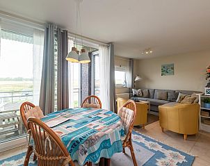 Gezellige woonkamer van vakantiehuis Nieuwendamme 40C in Lombardsijde, West-Vlaanderen, met uitzicht op de natuur en een comfortabele zithoek.