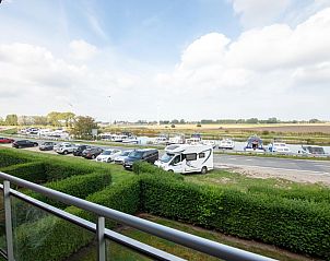 Uitzicht vanaf het balkon van vakantiehuis Nieuwendamme 40C in Lombardsijde, West-Vlaanderen, met zicht op de jachthaven en groene omgeving.