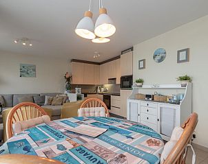 Gezellige eet- en woonkamer in vakantiehuis Nieuwendamme 40C, Lombardsijde, West-Vlaanderen, met moderne keuken en comfortabele zithoek.