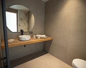 Moderne badkamer in Vakantiehuis in Houthulst, West-Vlaanderen, met elegant wastafelontwerp en sfeervolle verlichting.