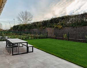 Genieen Sie die grozgige Terrasse des Ferienhauses Casa di Luna in Lombardsijde-Middelkerke, Westflandern, mit Blick auf einen grnen Garten.