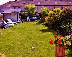 Spacious garden of vacation home Katica in Bredene, West Flanders with deck chairs and barbecue