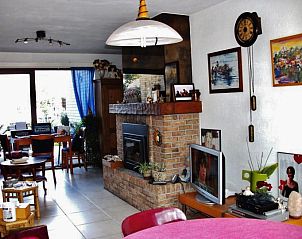 Cozy living room of vacation home Katica in Bredene, West Flanders with fireplace and artwork