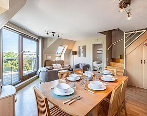 Gezellige woonkamer van vakantiehuis Donny in De Panne, West-Vlaanderen met ruime eethoek en uitzicht op de tuin vanuit grote ramen.