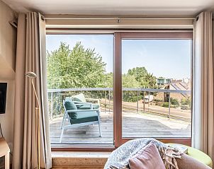 Geniet van het uitzicht op het terras van vakantiehuis Donny in De Panne, West-Vlaanderen, met comfortabele zitjes en groene omgeving.