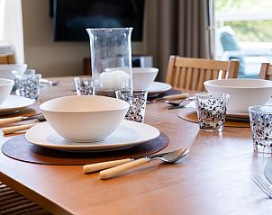 Gezellig gedekte eettafel in vakantiehuis Donny, De Panne, West-Vlaanderen, perfect voor familiediners in een sfeervolle omgeving.