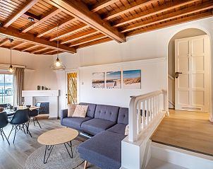 Gezellige woonkamer in vakantiehuis LaCte, Sint-Idesbald, met houten plafond en comfortabele zithoek in West-Vlaanderen, Belgi.