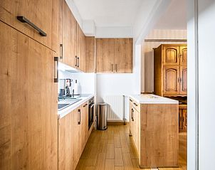 Moderne keuken in vakantiehuis Costa tweede, Sint-Idesbald, West-Vlaanderen, met houten kasten en stijlvolle apparatuur.