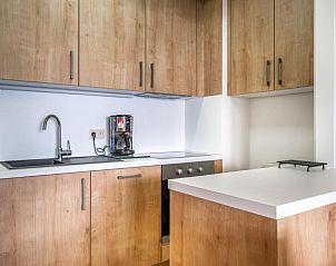 Moderne keuken in vakantiehuis Costa tweede in Sint-Idesbald, West-Vlaanderen, met houten kasten en strakke werkbladen.