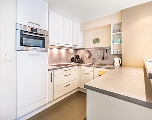 Moderne Kche in Anais drittem Ferienhaus, Sint-Idesbald, Westflandern, mit schlichten weien Schrnken und grozgigen Arbeitsflchen.