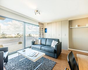 Stijlvolle woonkamer van vakantiehuis La Digue in Sint-Idesbald, West-Vlaanderen, met uitzicht op zee en moderne inrichting.