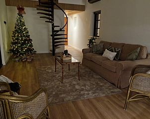 Cozy living room in Huisje in Ruiselede, a vacation home in West Flanders, complete with Christmas tree and comfortable seating area.