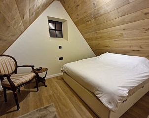 Cozy bedroom in Cottage in Ruiselede, vacation home in Ruiselede, West Flanders with wooden interior and comfortable furnishings.