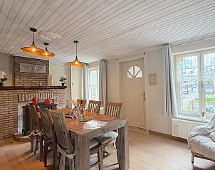 Gemtliches Esszimmer im Ferienhaus Bella Casa, Ramskapelle, Westflandern, mit Holztisch und Stranddekor fr eine heimelige Atmosphre.