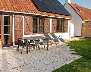 Sunny terrace of fisherman's cottage 76, Middelkerke, Belgian coast, with garden furniture and green area for relaxation.