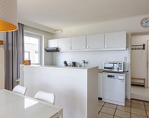 Modern kitchen in vacation home Kwintebank - 0904, located in Middelkerke, West Flanders, Belgium, with sleek white cabinets and dining area.