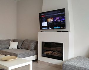 Gezellige woonkamer met open haard in Vakantiehuis Alegria, Westende, Belgi.